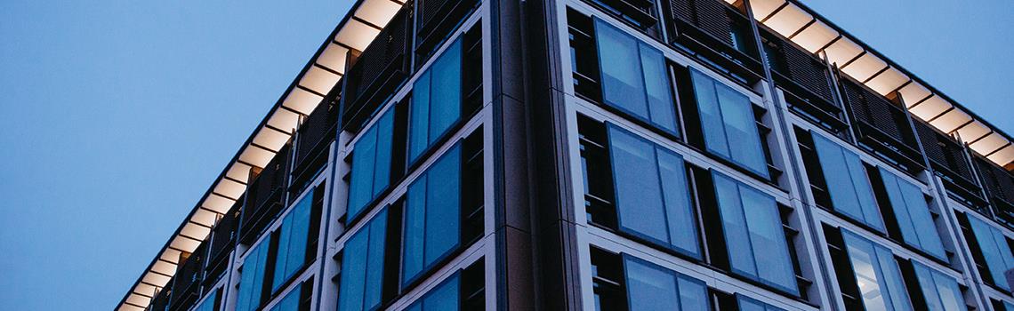 Photo of corner of building with ights on shot at dusk in blue light